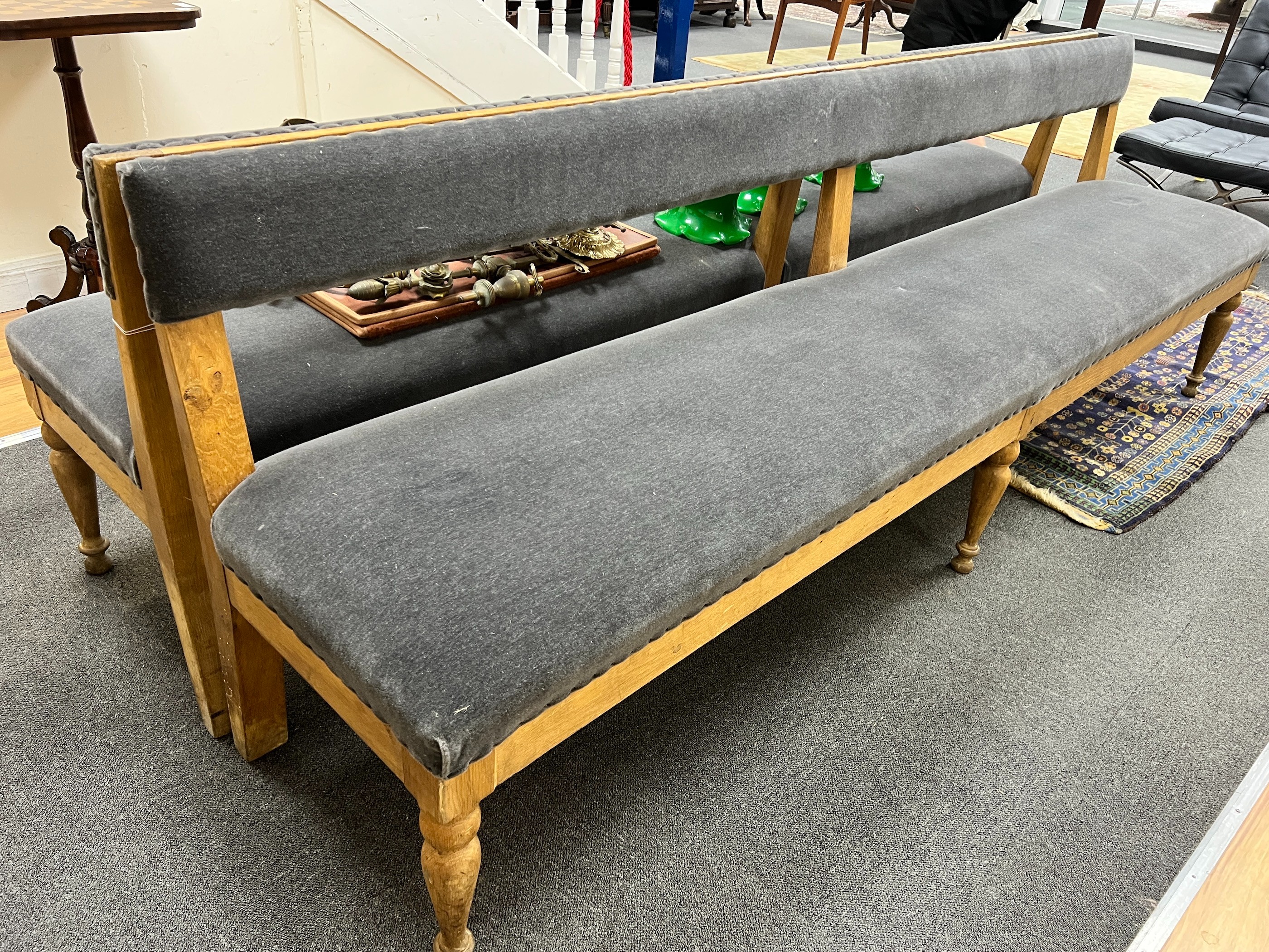 A pair of late Victorian pale oak upholstered benches, length 242cm, depth 48cm, height 80cm